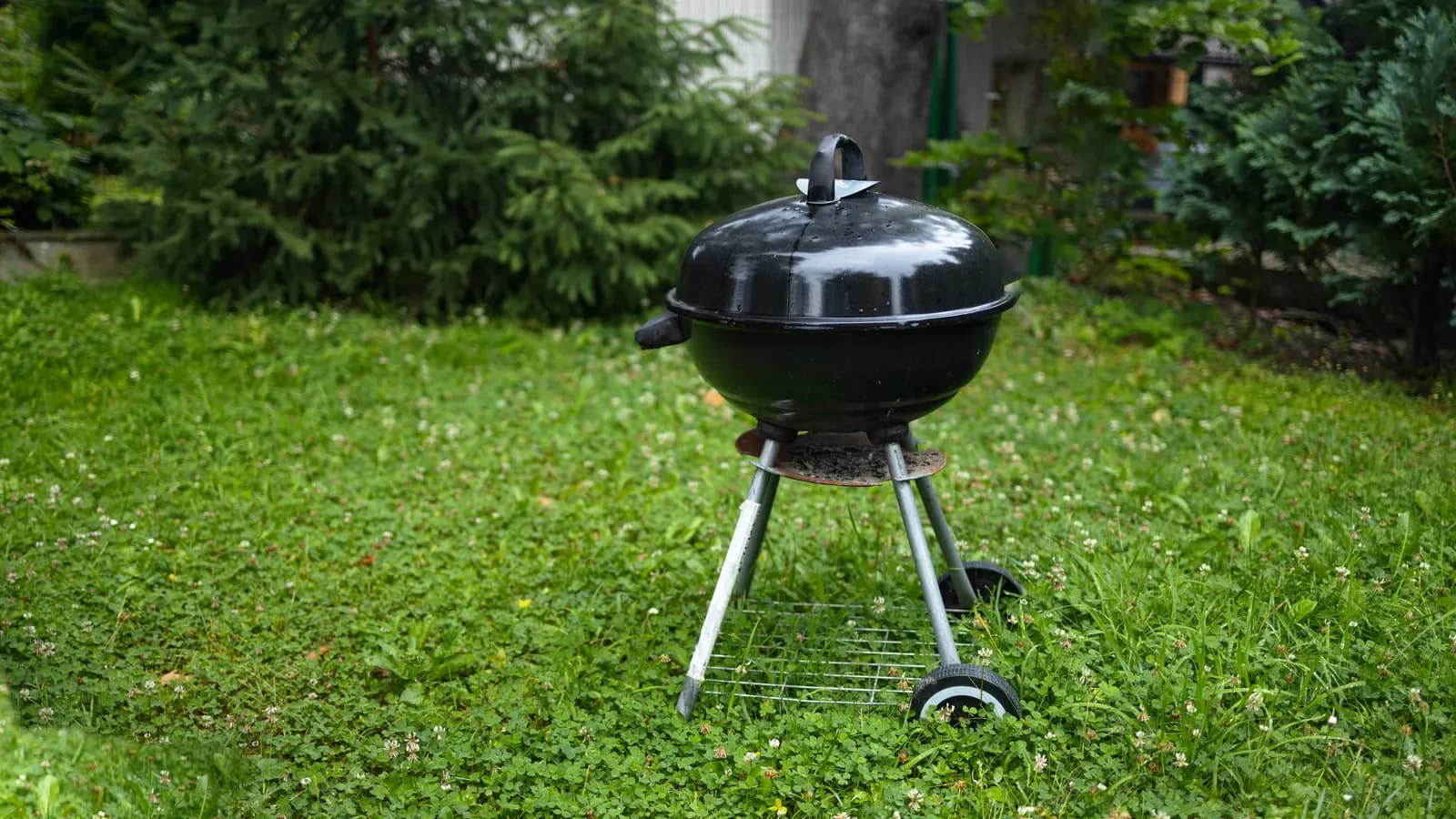 Barbecue sur pied protégé par une housse pour l'hiver