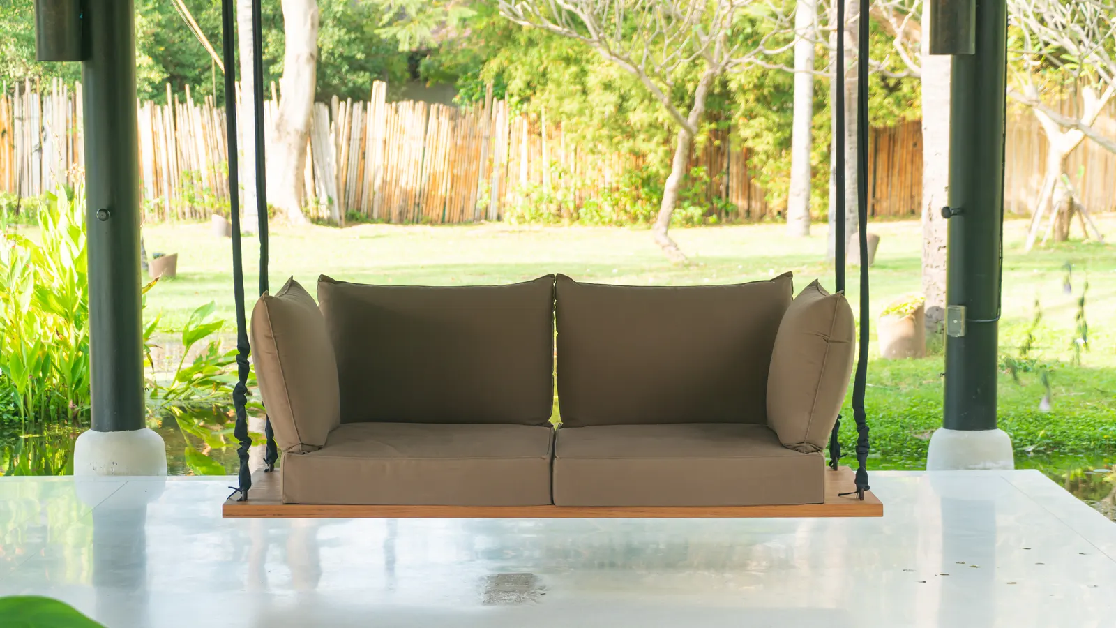 Balancelle de jardin installée dans un coin de verdure
