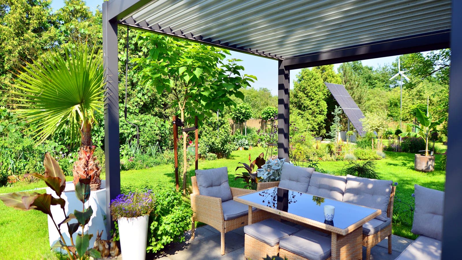 Terrasse extérieure meublée bordée d'un jardin luxuriant