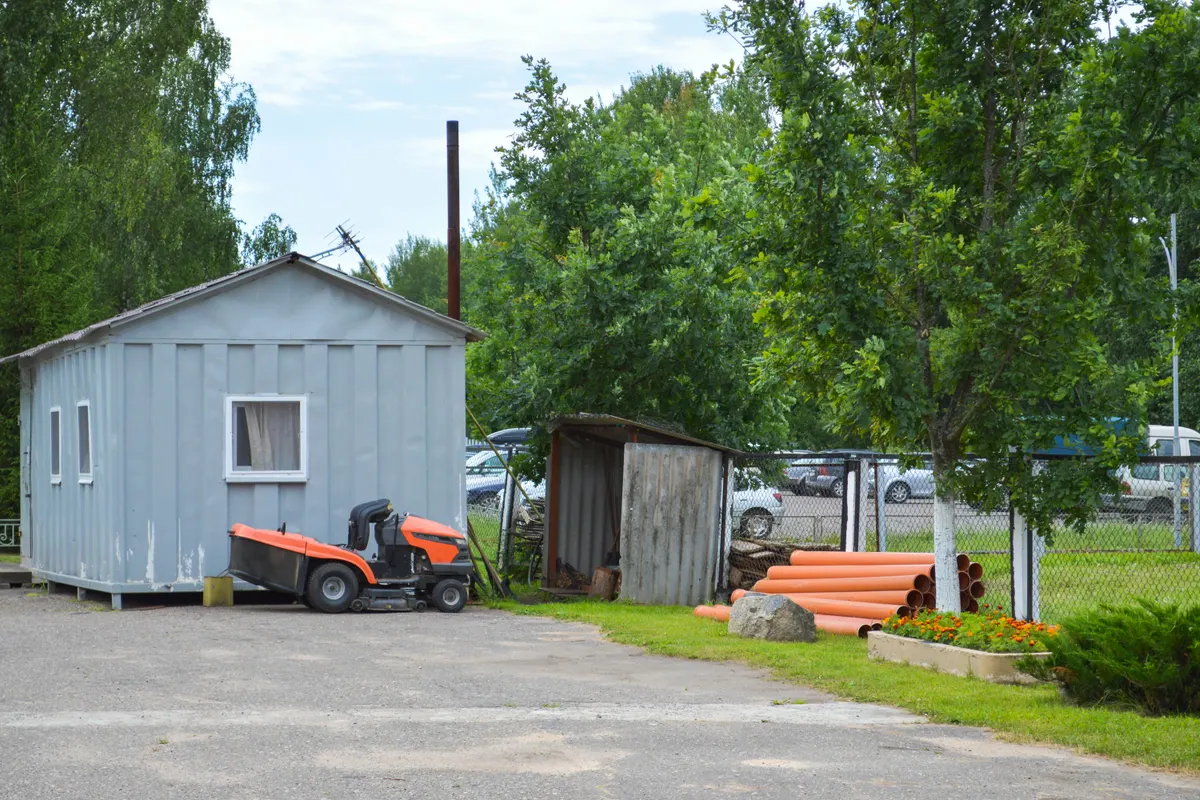 Encombrement d'un tracteur tondeuse devant une remise de jardin