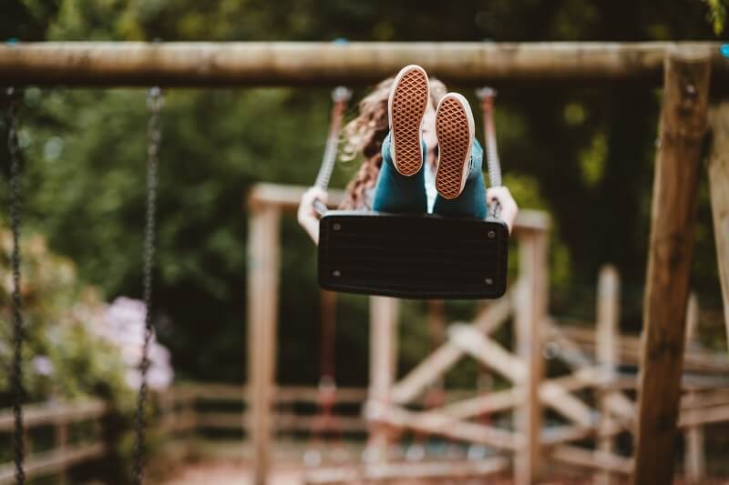 enfant faisaint de la balançoire dans une aire de jeux